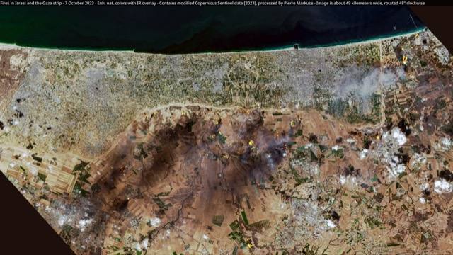 Satellite view of the Gaza Strip and southern Israel on 7 October 2023, with dozens of fires burning across farmland and smoke drifting inland from the coast.