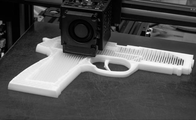A 3D printer building a white plastic handgun.