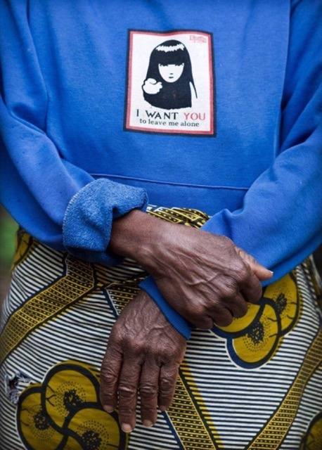A woman&rsquo;s folded hands; the patch on her sweatshirt reads I want you to leave me alone.